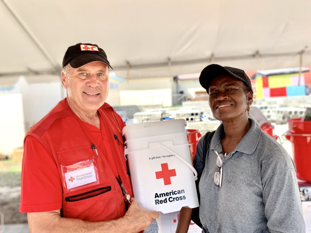 A Red Cross volunteer hands out supplies to Bahamas residents.