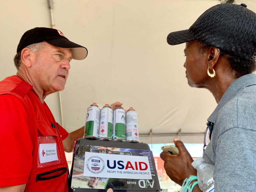 A Red Cross volunteer teaches a Bahamas resident how to use a portable stove for her meals. 