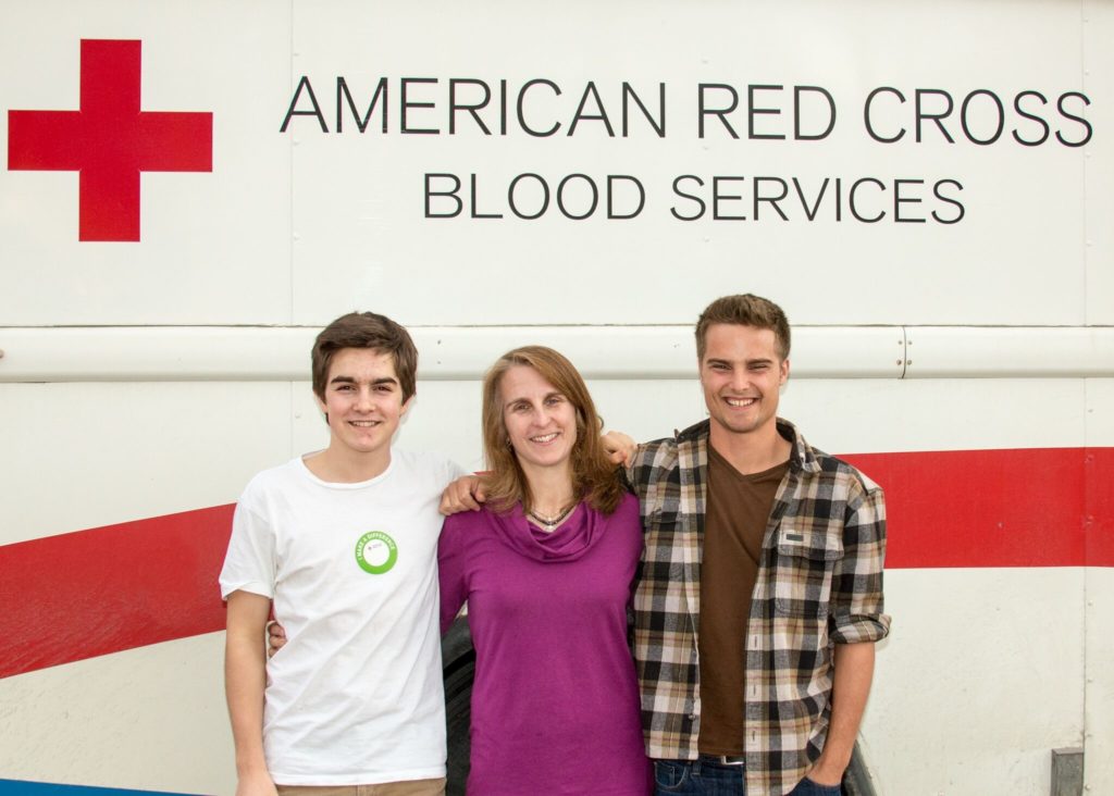 Jacob standing with his mother and brother after his blood donation.