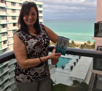 Manolita standing on a balcony in Miami with her Super Bowl tickets.